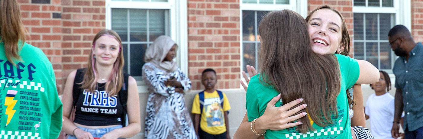 Students and teachers hugging on first day